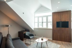 a living room with a couch and a tv on a wall at Vila Emilia in Vrnjačka Banja