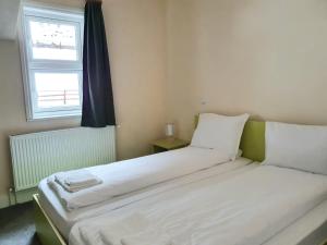 a bedroom with two beds and a window at Pensiunea Popas Pop, Strambu-Baiut, Maramures in Băiuţ