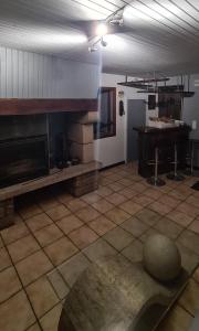 ein Wohnzimmer mit einem Kamin und einem Tisch in der Unterkunft les jonquilles in Bussière-Galant
