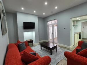 a living room with a red couch and a table at The Shed in Darlington