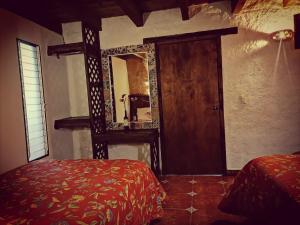 a bedroom with a mirror and a bed and a door at Hotel & Cava La Parroquia in San Cristóbal de Las Casas