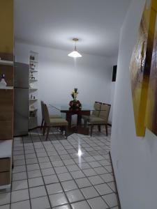 cocina y comedor con mesa y sillas en Apartamento na praia de Jatiuca, en Maceió
