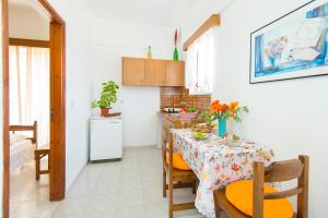 a kitchen with a table with chairs and a kitchen with a tableablish at Annabel Apartments in Theologos