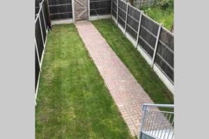 a garden with green grass and a fence at SEABREEZE in Kent