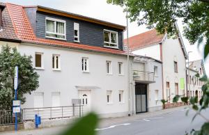 biały budynek z czerwonym dachem na ulicy w obiekcie main Appartments w mieście Kelsterbach