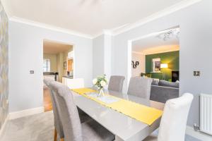 uma sala de jantar e sala de estar com uma mesa branca e cadeiras em Spacious and Modern Townhouse I Pass The Keys em York