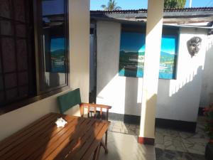 porche con banco de madera y ventanas en New Kivulini Bed and Breakfast, en Dar es Salaam