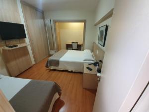 Uma TV ou centro de entretenimento em Via Contorno Hotel