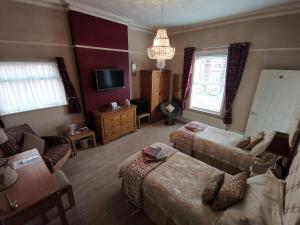 a living room with two beds and a couch at Vale House in Southport