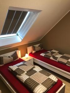 two beds in a attic room with a window at FeWo-Wieseck in Gießen