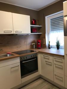 a kitchen with white cabinets and a stove top oven at FeWo-Wieseck in Gießen