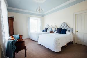 sypialnia z 2 łóżkami i krzesłem w obiekcie Tom Blake House w mieście Kells