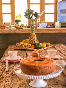 una mesa con una tarta en un mostrador con fruta en Casa do CAMPO Atins com super Conforto, en Atins
