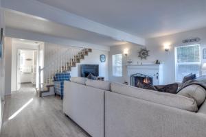 Una sala de estar con un sofá y una chimenea. en Beach Street Getaway- Seaside - Meredith Lodging, en Seaside