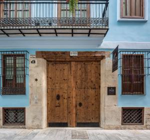 a wooden door on a blue building with a balcony at Mon Suites San Nicolas in Valencia
