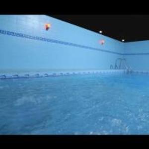 une grande piscine d'eau avec un mur blanc dans l'établissement Oasis Najran Hotel, à Najran