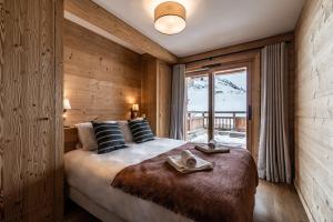 a bedroom with a large bed and a window at Apartment Wapa Alpe d'Huez - by EMERALD STAY in L'Alpe-d'Huez