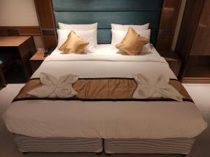 a bedroom with a large bed with white sheets and pillows at STAYMAKER Apex Hotel in Baharampur