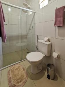 a bathroom with a toilet and a glass shower at Casa do Anjo in Fernando de Noronha