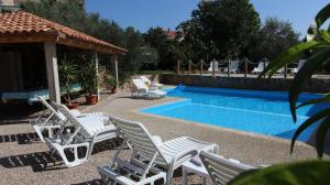 eine Gruppe von Stühlen neben einem Swimmingpool in der Unterkunft Apartments Kirinčić in Sveti Vid-Miholjice