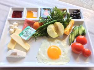 a tray with an egg and vegetables and other foods at Konak Hotel Kaleiçi in Antalya