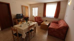ein Wohnzimmer mit Tisch und Couch in der Unterkunft Apartments Kirinčić in Sveti Vid-Miholjice