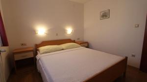 ein kleines Schlafzimmer mit einem Bett und zwei Nachttischen in der Unterkunft Apartments Kirinčić in Sveti Vid-Miholjice + 37 Fotos