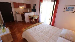 una camera da letto con un letto e una cucina con un tavolo di Apartments and Rooms Jelka a Malinska