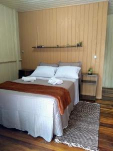 ein Schlafzimmer mit einem Bett mit zwei Handtüchern darauf in der Unterkunft Happy House - Casa ideal para grupos na cidade dos Canyons in Praia Grande