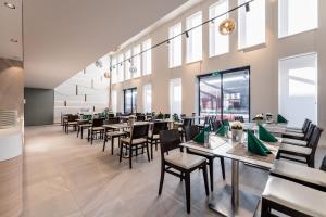 un comedor con mesas, sillas y ventanas en Globall Hotel, en Telki