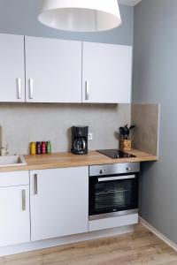 een keuken met witte kasten en een zwarte magnetron bij Apartment an der Altstadt (#8) in Hameln