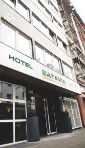 a large building with a sign on the front of it at Hotel Batavia in Düsseldorf