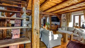 una sala de estar con muebles y techo de madera. en Siedlisko Borówkowo en Jeziorany