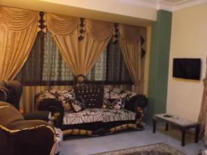 a living room with a couch in front of a window at One-Bedroom Apartment at El Maali Street in Cairo