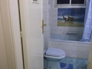 a bathroom with a toilet and a picture on the wall at One-Bedroom Apartment at El Maali Street in Cairo