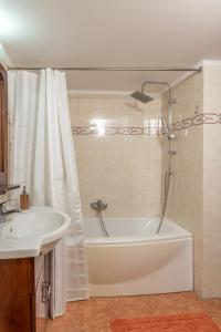 a bathroom with a tub and a sink and a shower at La Maison de Penelope in Límnai +13 photos