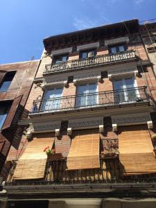 un antiguo edificio de ladrillo con ventanas y balcones en Piso céntrico y funcional, en Madrid