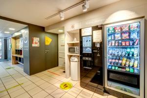 uma mercearia com um grande frigorífico com refrigerante em B&B HOTEL Louveciennes em Louveciennes