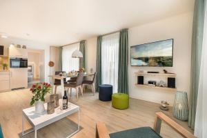 a living room with a table and a dining room at Apartmenthaus Am Park Am Park 23 in Prerow