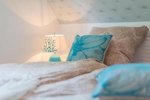 - une chambre avec un lit doté d'oreillers bleus et d'une lampe dans l'établissement Haus am Strand Ferienwohnung Haus am Strand 2, à Zingst