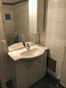 łazienka z białą umywalką i lustrem w obiekcie City Apartments Klinikum w mieście Klagenfurt