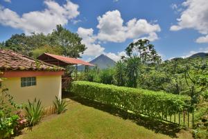 a house with a fence and mountains in the background at Casa Mirador Private and Cozy house Walking distance from Restaurants and Attractions in El Castillo de la Fortuna