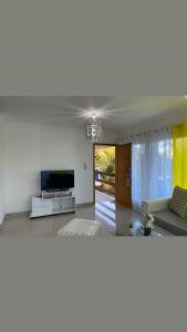 ein Wohnzimmer mit einem Sofa und einem TV in der Unterkunft JCS SEIJAS APARTAMENT Recidence and Beach Club, 3E in Pajarito