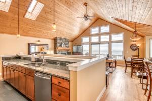 a kitchen with wooden ceilings and a dining room at Looking Glass Inn in Depoe Bay