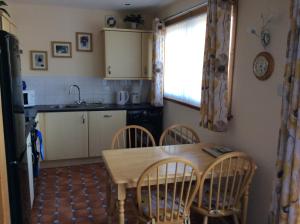 a kitchen with a table and chairs and a window at Heron Lodge, edge of Mabie Forest Dumfries in Dumfries