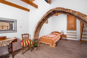 a bedroom with a bed and a table and a chair at La Maison de Penelope in Límnai