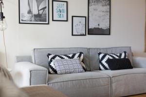 a living room with a gray couch with pillows on it at Bizstay Harbour II Scheveningen Apartments in Scheveningen