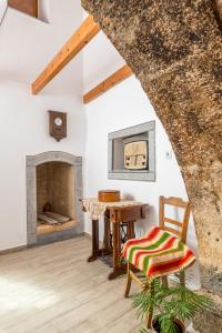 a room with a table and a chair and a fireplace at La Maison de Penelope in Límnai