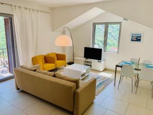 ein Wohnzimmer mit einem Sofa und einem Tisch in der Unterkunft Lavender Bay Apartment C33 in Donji Morinj