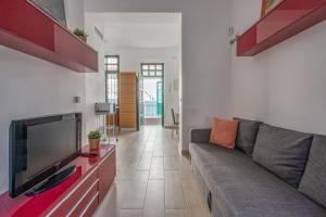 een woonkamer met een bank en een flatscreen-tv bij Triana Flat, 3mn from plaza de Cuba in Sevilla